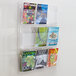 A Safco Reveal clear wall-mount magazine rack filled with magazines.