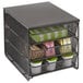 A black metal wire mesh drawer with three containers inside.