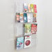 A Safco clear acrylic wall-mount magazine rack filled with magazines.