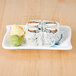 A sushi roll with avocado and cucumber on a Thunder Group Blue Bamboo melamine plate.