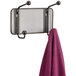 A Safco steel mesh coat rack with two pegs holding a purple towel.