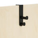 A black plastic double coat hook on a wooden door.