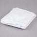 A folded white L.A. Baby crib pad cover on a gray surface.