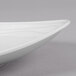 A close-up of a white oval melamine platter with a textured rim.