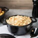 A bowl of macaroni and cheese in a Lodge cast iron Dutch oven.