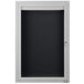 A white cabinet with a black door with a black letter board inside.