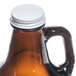 A Libbey amber glass growler with a white lid.
