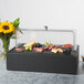 A black Vollrath food display platter with food inside and a clear lid.