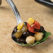 A Bon Chef sombrero bouillon tasting spoon filled with black beans, corn, and peppers.