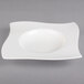 A white Villeroy & Boch porcelain deep plate with a curved edge and wavy design.