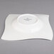 A Villeroy & Boch white porcelain deep plate with a wavy design on the edge.