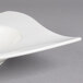 A Villeroy & Boch NewWave white porcelain deep plate with a curved edge on a gray surface.