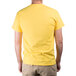 A man wearing a yellow "We Squeeze To Please" T-shirt.
