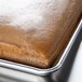 A brown cake in a half-size pan with a MFG Tray fiberglass pan extender.