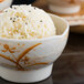 A bowl of rice with black and white rice served in a Thunder Group Gold Orchid melamine rice bowl.