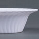 A close up of a white Fineline Flairware plastic bowl with a wavy design.