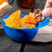 A blue mini baseball helmet bowl filled with a pretzel and chips.