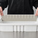 A person holding a Long Metro gray plastic tote box divider.