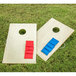 A Triumph cornhole game set with rectangular wooden boards and a hole in the center with red and blue bags on them.