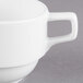 A close up of a Libbey Alpine White porcelain stacking cup with a handle.