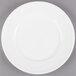 A Libbey alpine white porcelain plate with a white rim on a gray surface.