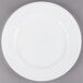 A Libbey alpine white porcelain plate with a rim on a gray surface.