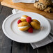 A Libbey alpine white porcelain plate topped with cookies and raspberries.