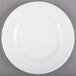 A Libbey alpine white porcelain plate with a rim on a gray surface.