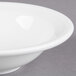 A Libbey Alpine White Porcelain grapefruit bowl with a rim on a gray surface.