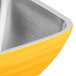A close up of a square yellow stainless steel Vollrath serving bowl.