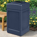 A dark blue Commercial Zone PolyTec waste container sitting next to a bench.