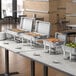 A buffet table with a Choice Economy stainless steel chafer on it filled with food trays.