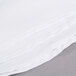 A stack of white Intedge poly/cotton blend table cloths.