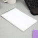 A white spiral bound TOPS steno notebook on a desk.