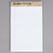 A white notepad with narrow ruled lined paper.
