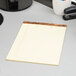 A TOPS wide ruled canary legal pad on a desk.