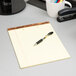 A pen on a TOPS canary legal pad.