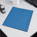 An Oxford blue paper pocket folder on a white desk.