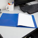 A blue Oxford 2-pocket folder with lined paper on a desk.