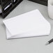 A close-up of a stack of Oxford white ruled index cards.
