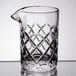An Arcoroc clear glass stirring pitcher with a diamond pattern and a handle.