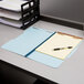 A Pendaflex legal size fastener folder with papers and a pen on it.