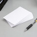 A close-up of a pen next to a stack of Oxford white index cards.