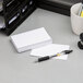 A stack of Oxford white unruled index cards on a desk with a pen.