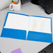 An Oxford blue high gloss laminated paper pocket folder.