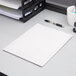 An Oxford white embossed paper pocket folder on a white surface with a pen on top.