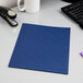 An Oxford navy blue linen paper pocket folder on a white surface.