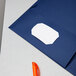 A navy blue Oxford 2-pocket folder with a white paper inside.