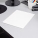 A white Oxford paper pocket folder on a gray surface.