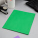 A light green Oxford paper pocket folder on a desk.